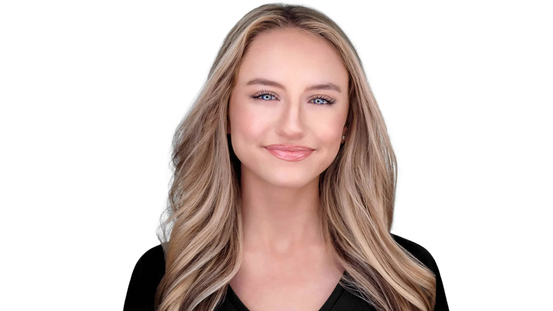Woman with long flowing blonde waves and honey highlights, black v-neck top, warm confident smile, white studio background