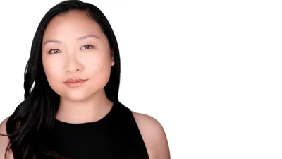 Asian female professional LinkedIn headshot with long straight black hair parted on side, natural makeup with nude lips, wearing black sleeveless top, photographed on seamless white background by Lancaster Pennsylvania headshot photographer Richard Waine, ideal business profile picture demonstrating approachability and professionalism