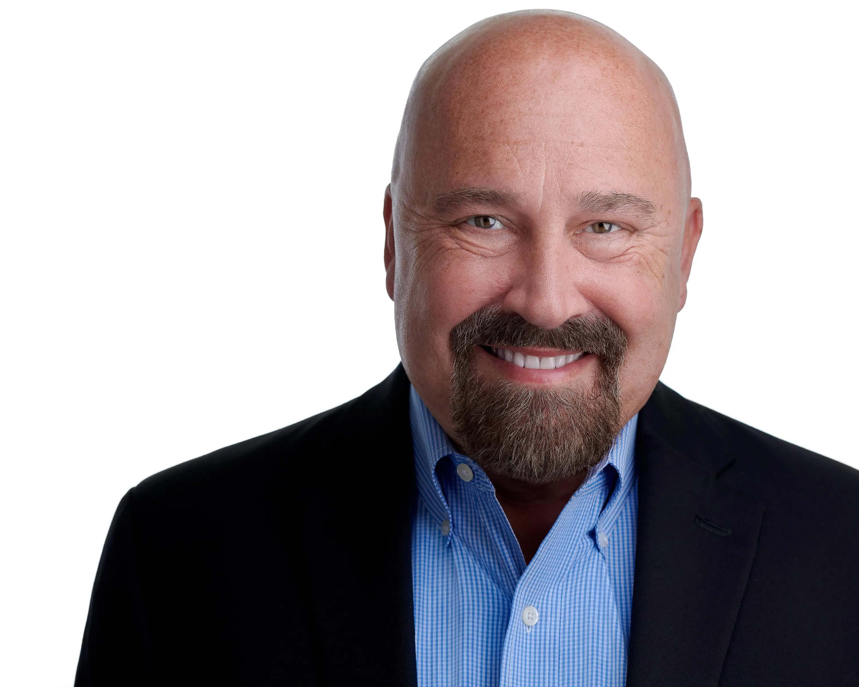 Bald man with well-groomed goatee wearing black blazer over light blue checkered shirt, warm approachable smile, white background