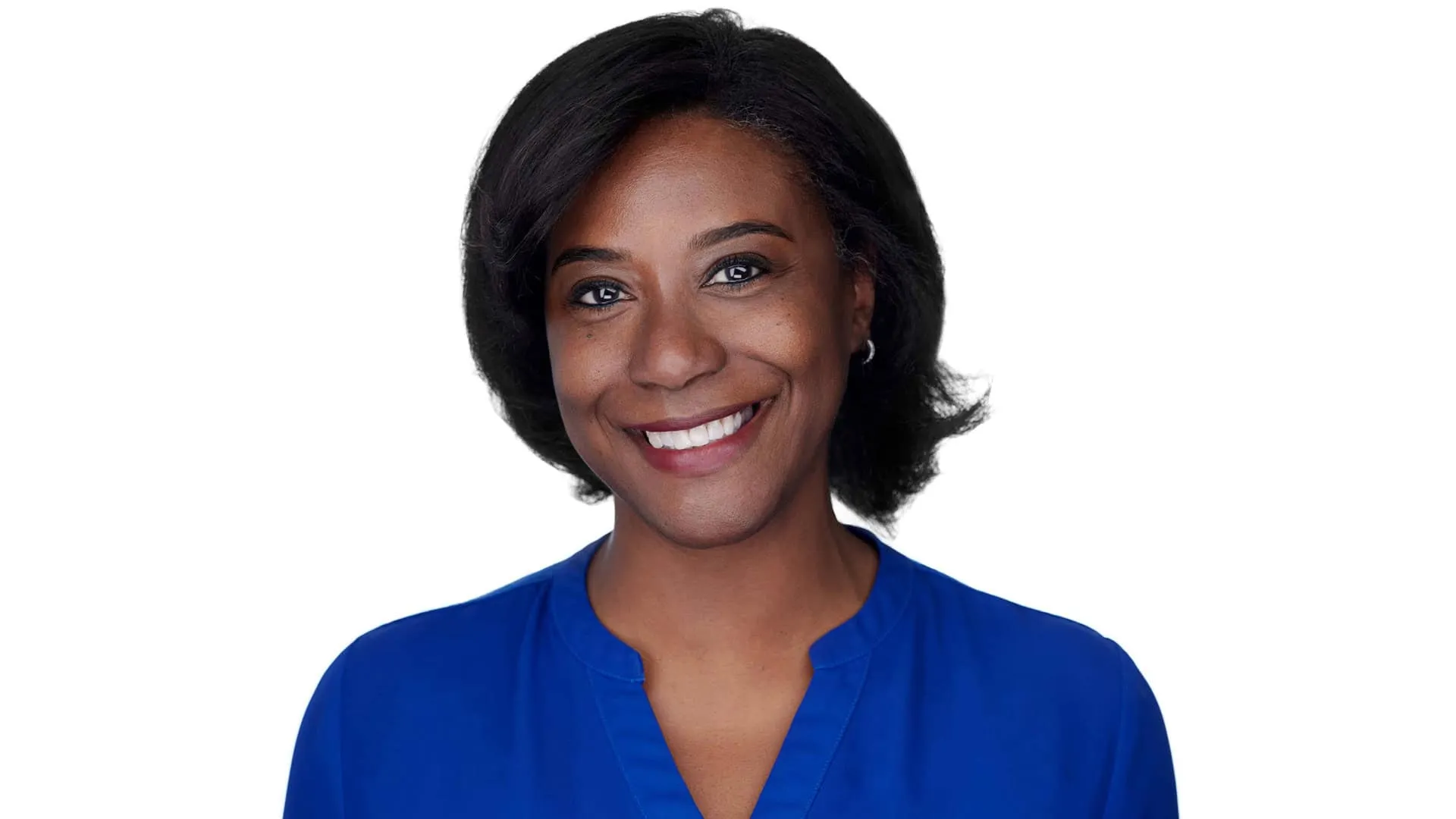 Professional headshot of African-American female with shoulder-length black wavy bob hairstyle, small silver hoop earrings, bright white smile showing teeth, wearing royal blue v-neck top, photographed on seamless white background in Baltimore, Maryland by headshot photographer Richard Waine