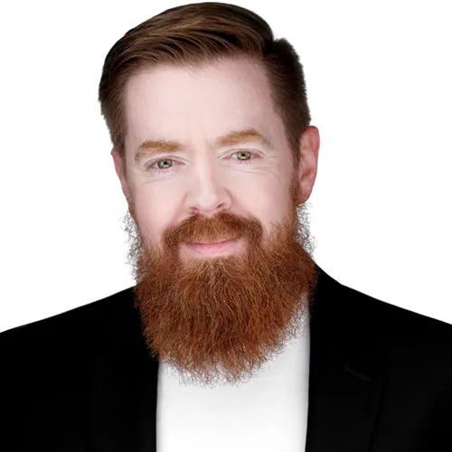 Professional linkedin profile headshot of male project manager with short styled reddish-brown hair and full long reddish-brown beard wearing black suit jacket over white dress shirt photographed against white studio background by Richard Waine Photography Lancaster