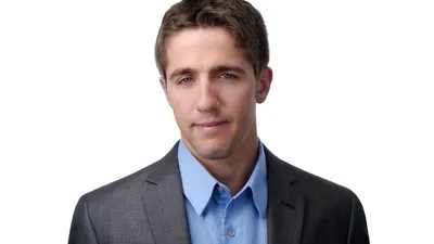 Male professional headshot with short dark brown hair, wearing charcoal grey suit jacket over light blue dress shirt, photographed on seamless white background by Lancaster Pennsylvania headshot photographer Richard Waine
