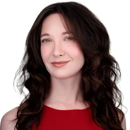 Professional acting headshot of woman with long dark brown wavy hair and warm smile wearing red sleeveless top against seamless white studio background by Richard Waine Photography